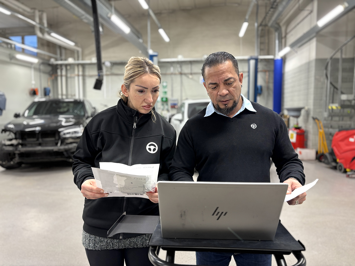Kvinna och man på bilverkstad