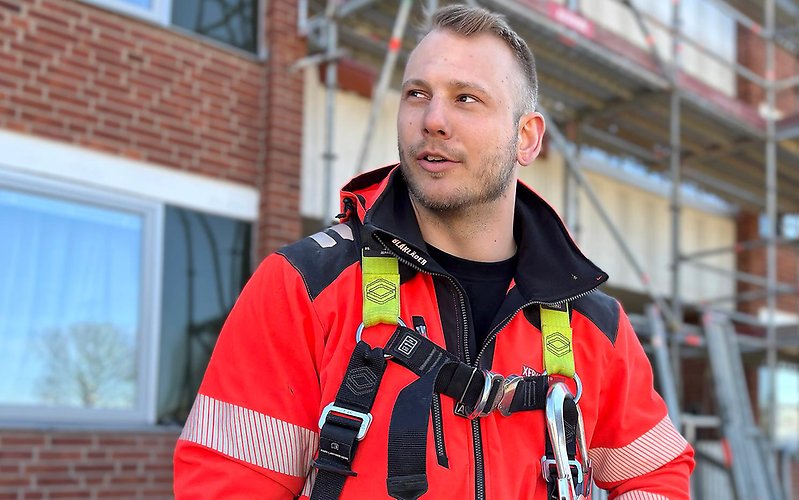 Man i arbetskläder som arbetar som ställningsbyggare 