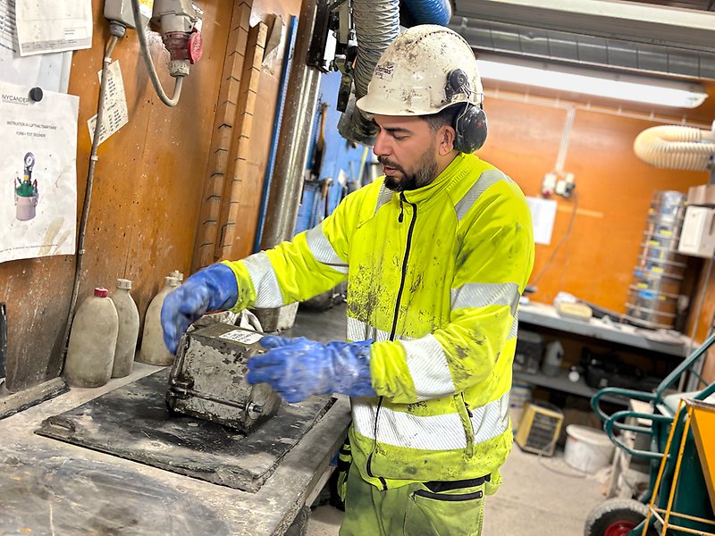 En man står och jobbar i en betongfabrik