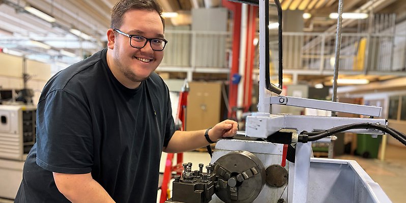 En man och står framför maskineri.