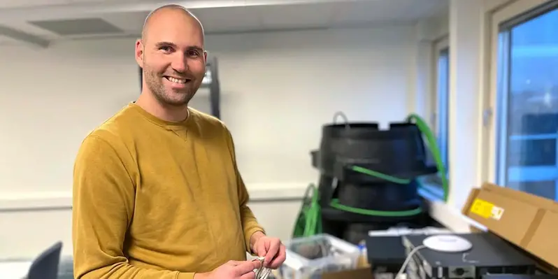 En man och står framför en mängd nätverksutrustning.