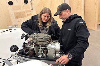 En man och en kvinna står framför en CNC-maskin.